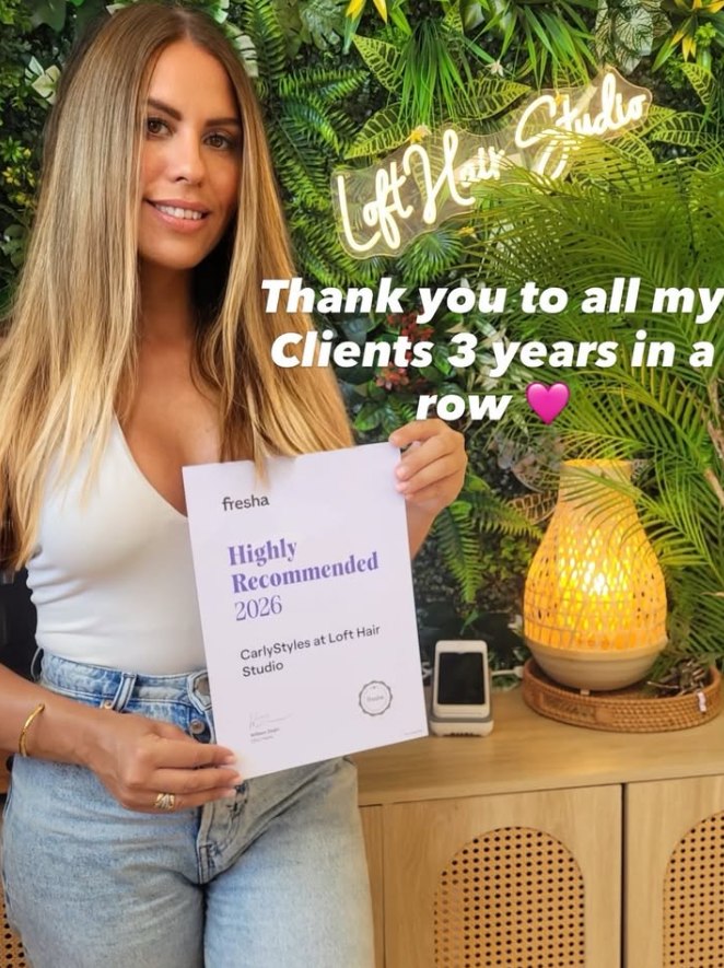Carly Styles holding her Fresha Highly Recommended award at The Loft Hair Studio