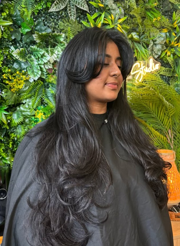 Glossy long black hair with curtain layers at The Loft Hair Studio