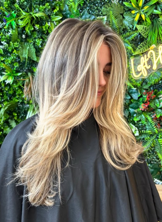 Bright blonde ribbons through a brunette base at The Loft Hair Studio